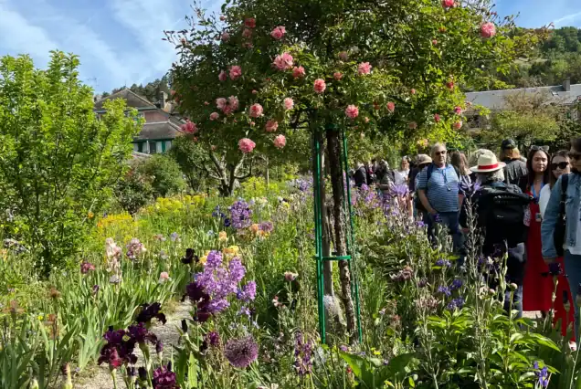 Private tour group walking through the flower-lined paths of Giverny Monet’s Gardens