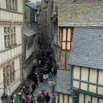 Mont Saint Michel fountain and medieval village street scene on day tour from Paris