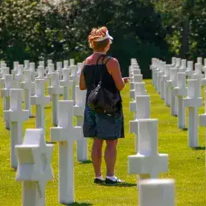 Woman reflecting at the American Cemetery during WWII Normandy day trip from Paris